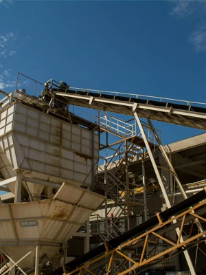 Abrasion-resistant rubber conveyor belt transporting dry clinker and cement materials on an inclined industrial handling system.