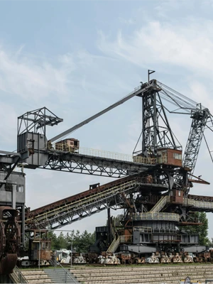 Heavy-duty rubber conveyor belt operating on large-scale ore extraction machinery in an open-pit mine.